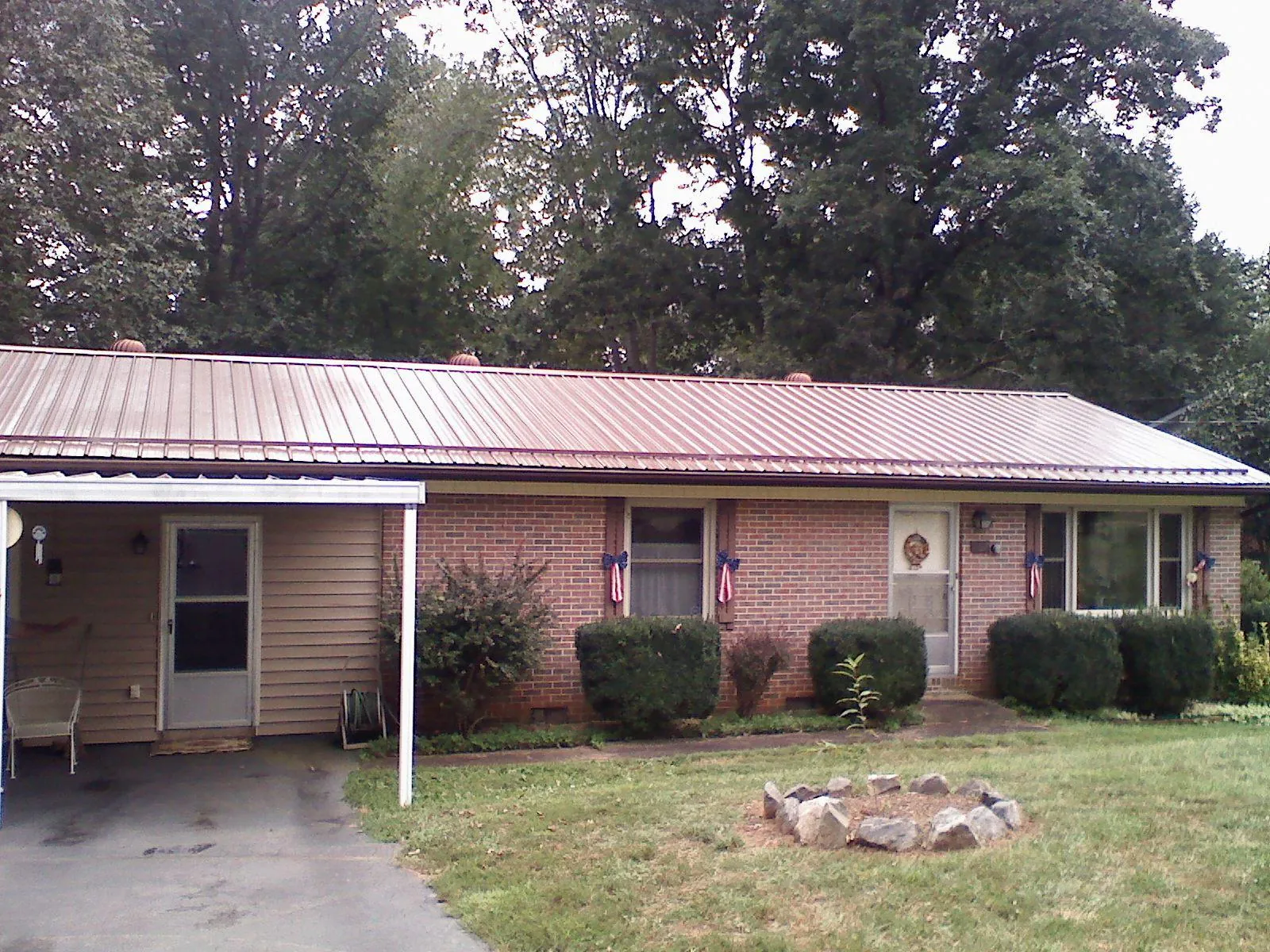 Bronze metal roof and carport on a brick ranch home — Roof Repair work by our crew in Goehner
